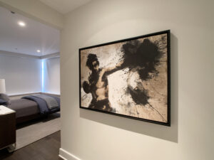 A bedroom shows a framed art piece on the wall. The art shows a fighter or warrior punching with a cloud of black covering his fist.