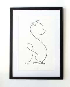 A framed drawing of the outline of a small dog in a black frame. Peterson Picture Co. carefully glazes it from a selection of four glaze options.