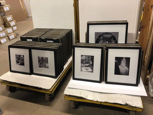 Peterson Picture Co.'s experts are well versed in commercial framing. We can create custom frames that meet any projects needs or scale. The example shows a zoomed-out image of four different-sized black frames with various matting styles is placed in the warehouse, ready for fulfillment.